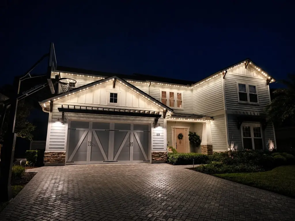 Warm white lighting follows the rooflines of a two-story home.